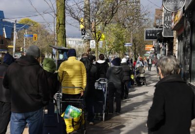 people lined up on sidewalk at Fort York Food Bank
